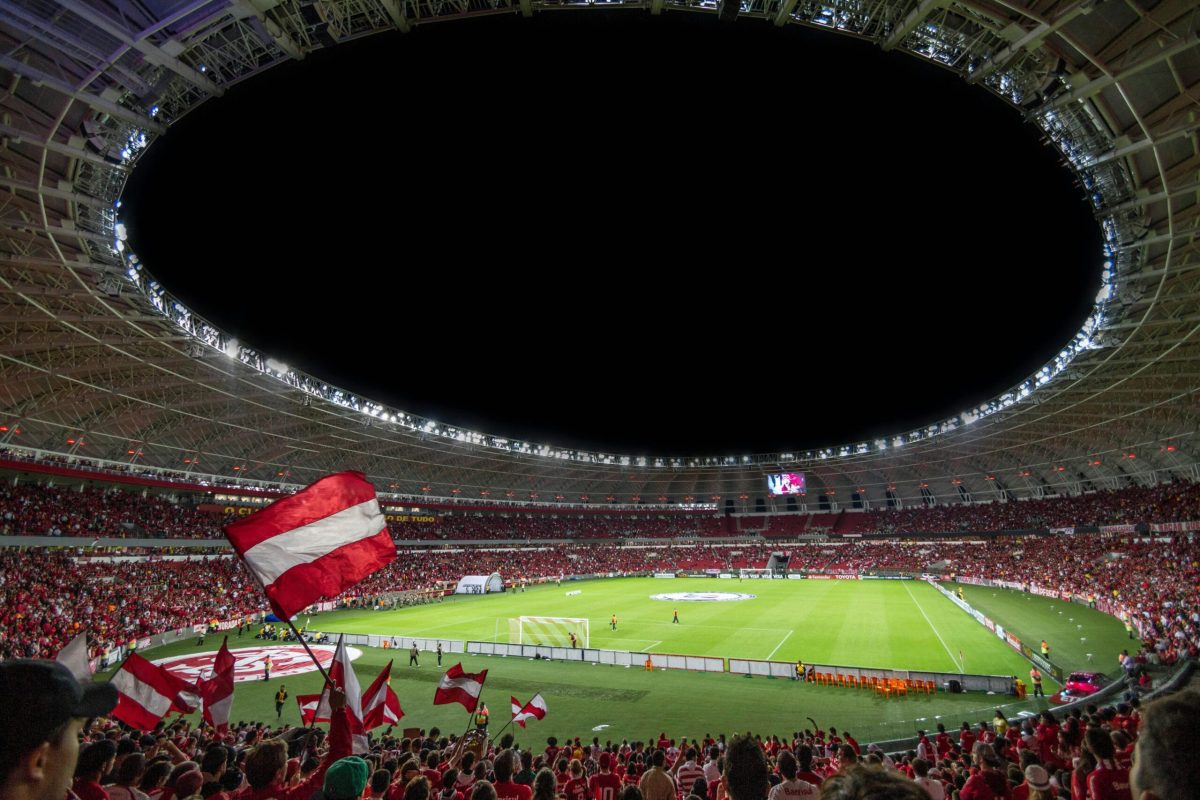 Exciting soccer match with enthusiastic fans in a packed stadium under bright lights.